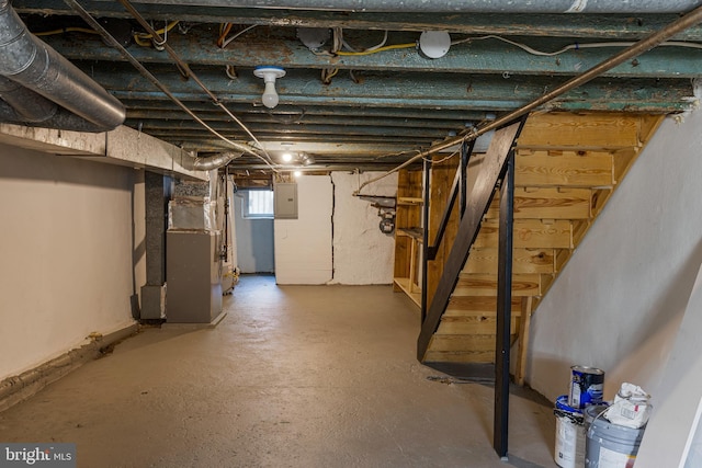 basement featuring heating unit and electric panel