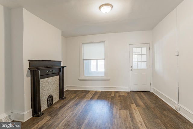 unfurnished living room featuring dark hardwood / wood-style flooring and plenty of natural light