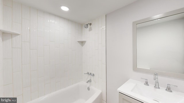 bathroom featuring vanity and tiled shower / bath