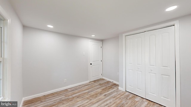 unfurnished bedroom featuring a closet and light hardwood / wood-style floors