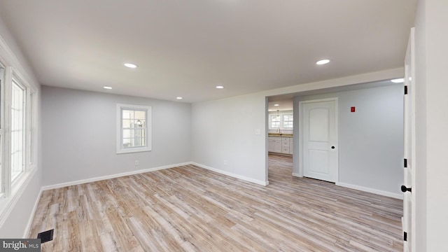 unfurnished room with light hardwood / wood-style floors and sink