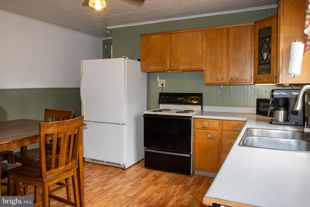 kitchen featuring white appliances, light hardwood / wood-style flooring, crown molding, ceiling fan, and sink