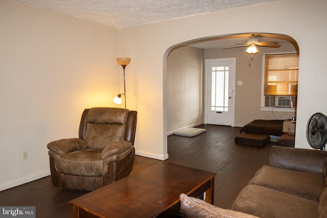 living room featuring ceiling fan, cooling unit, dark hardwood / wood-style flooring, and a textured ceiling