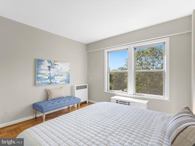 bedroom with radiator, parquet floors, and a wall mounted air conditioner