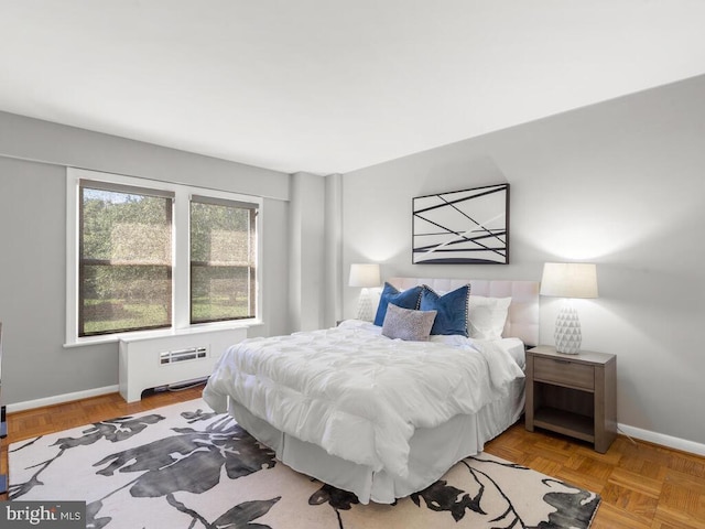 bedroom with light parquet flooring and radiator heating unit