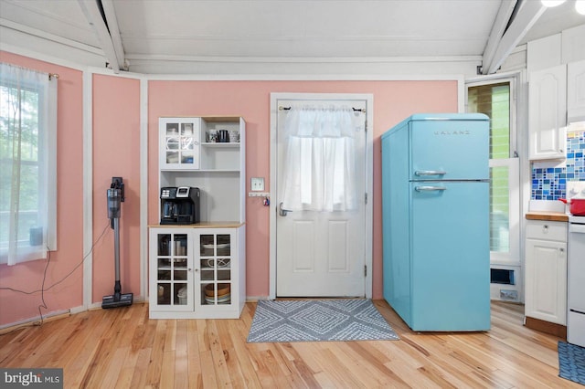 kitchen featuring tasteful backsplash, light hardwood / wood-style flooring, white fridge, and white cabinetry