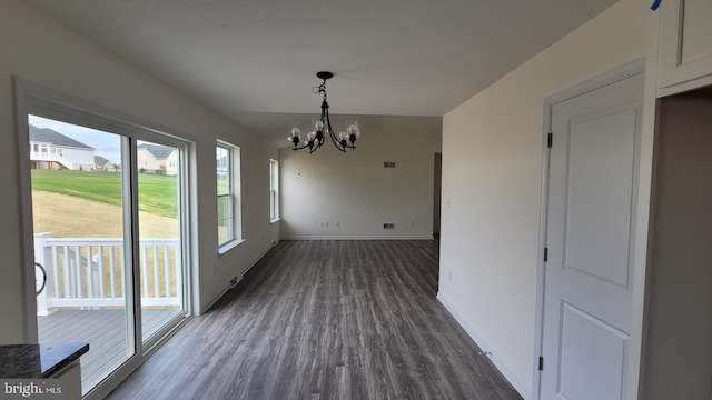 unfurnished dining area with hardwood / wood-style flooring and a chandelier