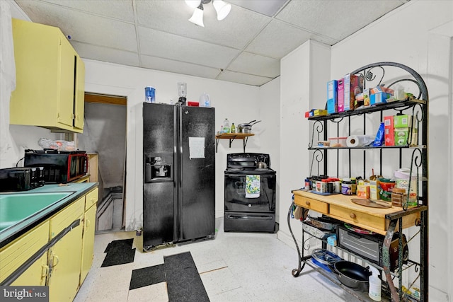 kitchen featuring sink, black appliances, light tile patterned floors, and a paneled ceiling