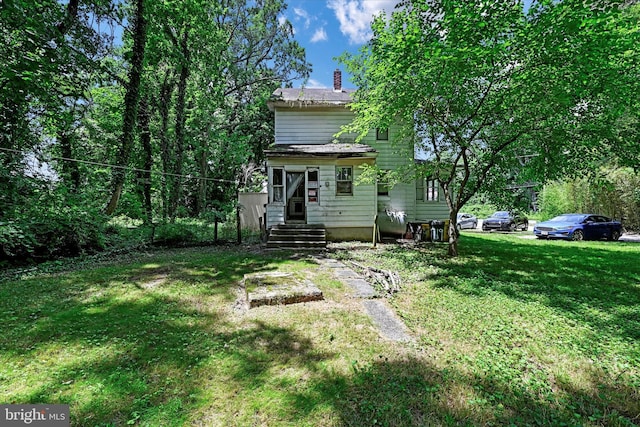 rear view of property with a lawn