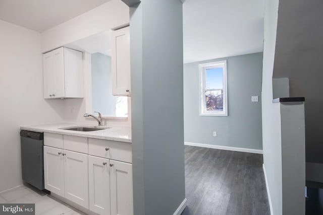 kitchen with dishwasher, sink, white cabinetry, light hardwood / wood-style flooring, and light stone counters