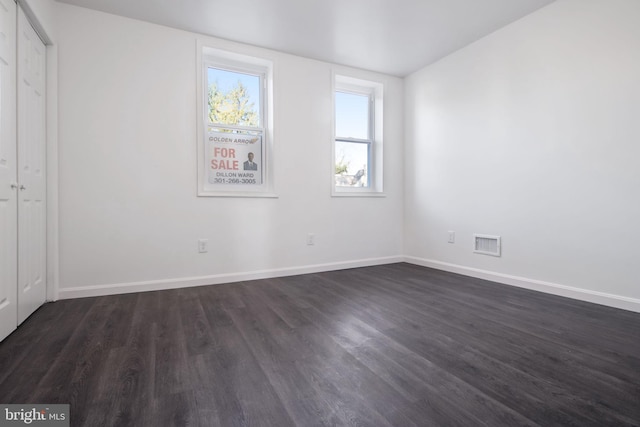 spare room with lofted ceiling and dark hardwood / wood-style floors