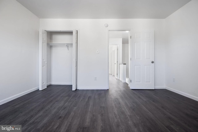 unfurnished bedroom featuring a closet and dark hardwood / wood-style floors