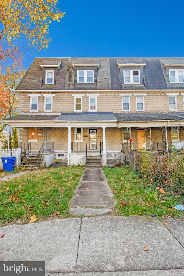 townhome / multi-family property featuring covered porch