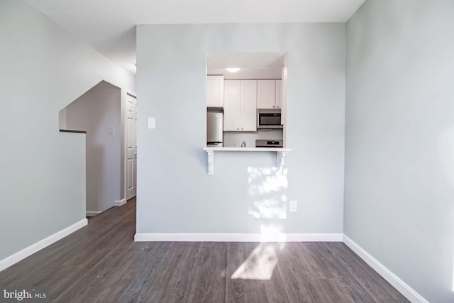 unfurnished living room with dark wood-type flooring