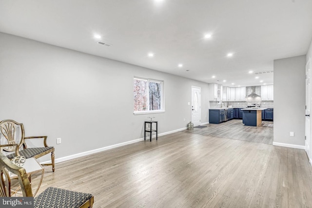 living room featuring sink and light hardwood / wood-style flooring