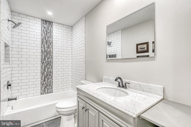 full bathroom featuring vanity, tile patterned flooring, tiled shower / bath combo, and toilet