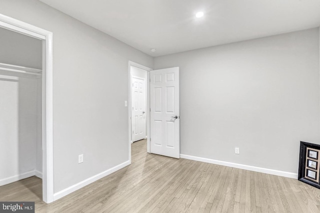 unfurnished bedroom featuring light hardwood / wood-style floors and a closet