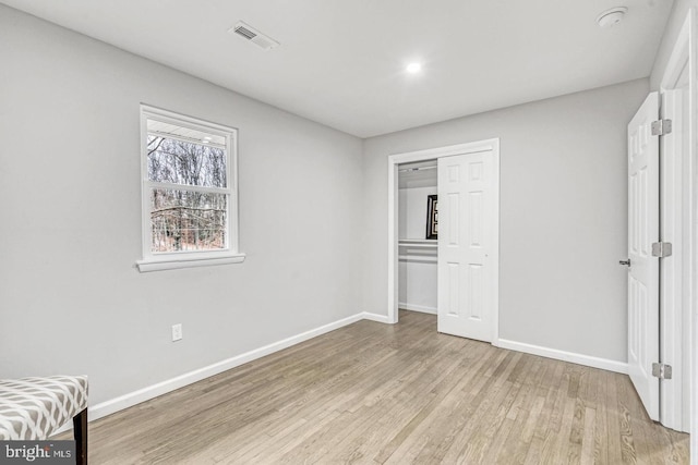 unfurnished bedroom featuring light hardwood / wood-style floors and a closet