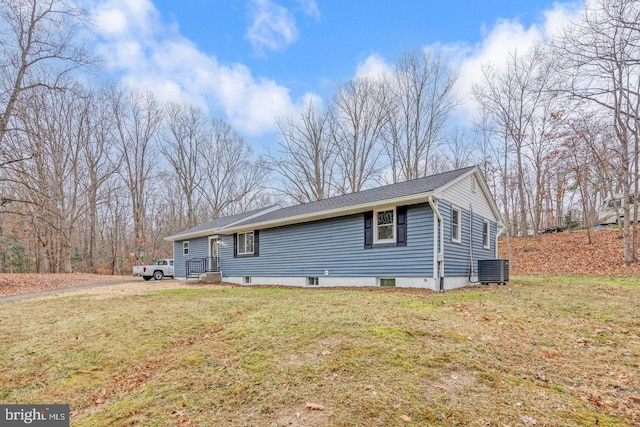 view of front of house with central AC unit and a front yard