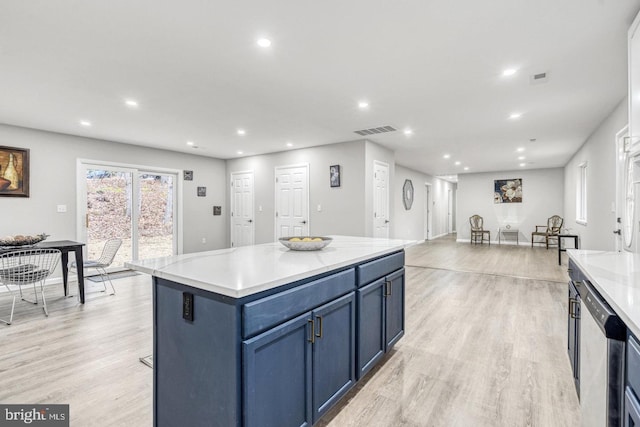 kitchen with blue cabinets, a kitchen island, stainless steel dishwasher, and light hardwood / wood-style floors