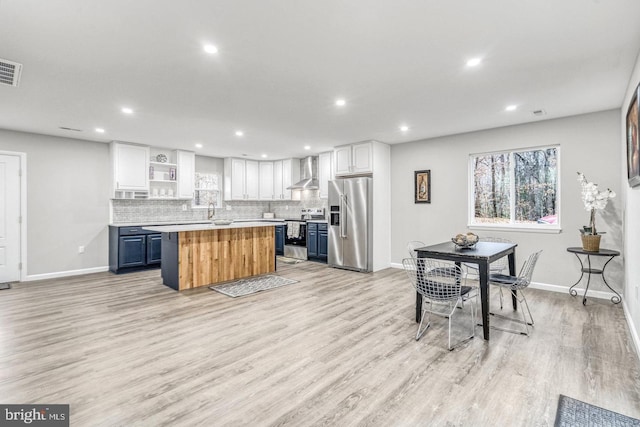 kitchen featuring blue cabinets, a center island, white cabinets, and stainless steel appliances