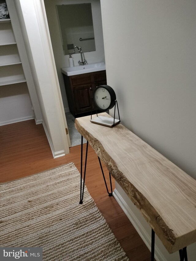 corridor featuring sink and light wood-type flooring