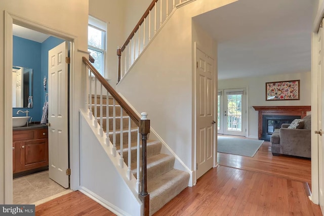 stairway with sink and hardwood / wood-style floors