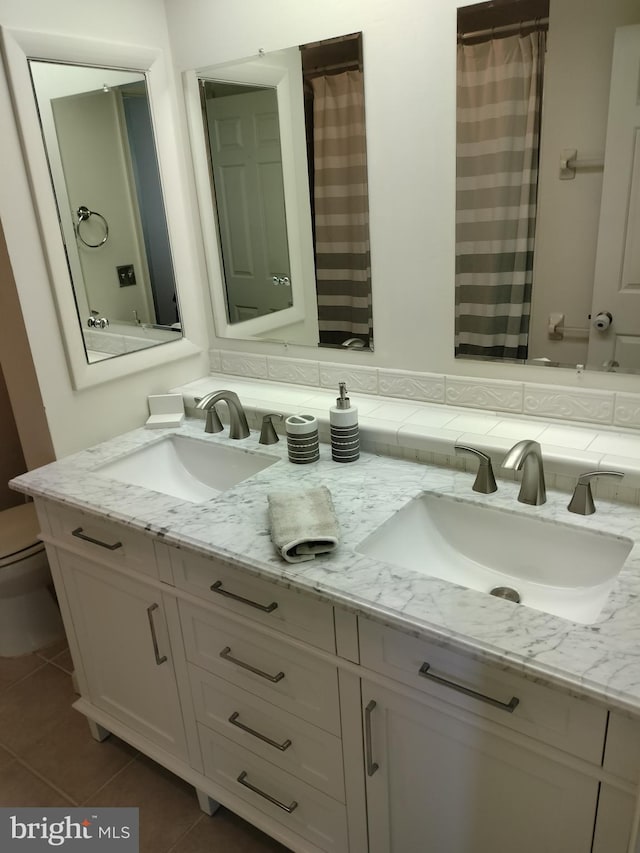 bathroom with tile patterned flooring, vanity, and toilet