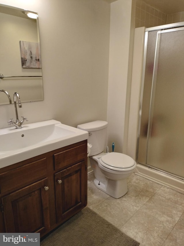 bathroom with a shower with door, vanity, and toilet