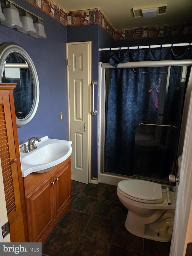 bathroom featuring tile patterned floors, toilet, walk in shower, and vanity