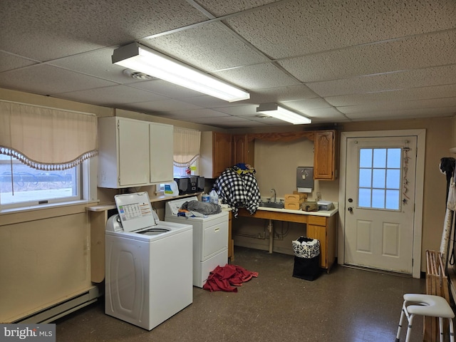 laundry room featuring a baseboard heating unit, cabinets, and washer and clothes dryer