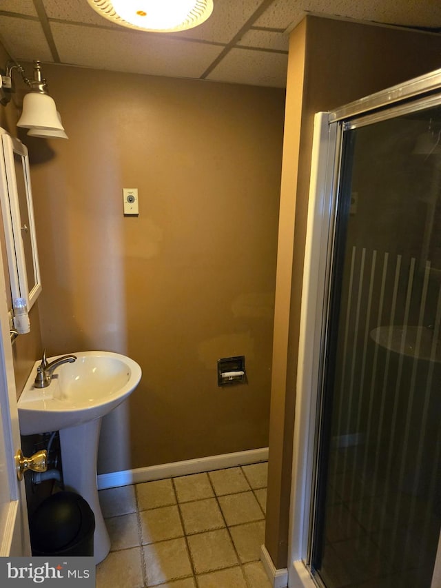 bathroom with sink, an enclosed shower, and a paneled ceiling