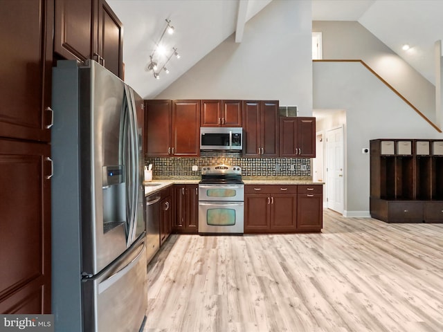 kitchen featuring appliances with stainless steel finishes, tasteful backsplash, high vaulted ceiling, light wood-type flooring, and track lighting