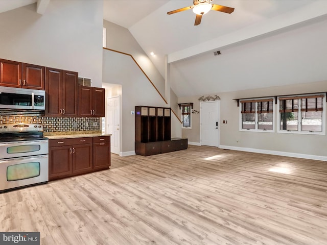 kitchen with light wood-type flooring, high vaulted ceiling, range with two ovens, ceiling fan, and decorative backsplash