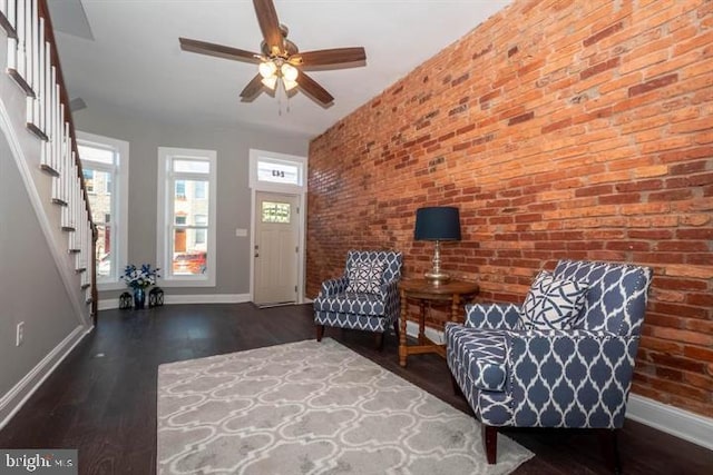 unfurnished room featuring ceiling fan, brick wall, and dark hardwood / wood-style floors