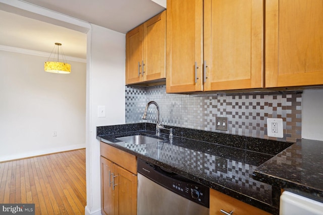 kitchen with sink, dark stone countertops, dishwasher, and hardwood / wood-style floors