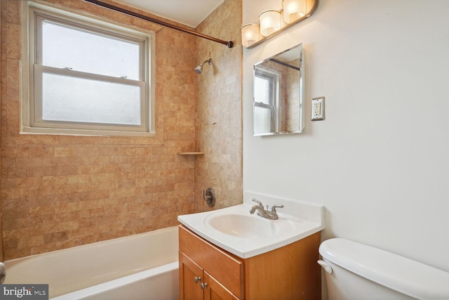 full bathroom featuring tiled shower / bath, vanity, a healthy amount of sunlight, and toilet