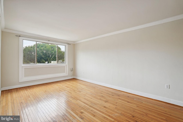 empty room with light hardwood / wood-style floors and ornamental molding