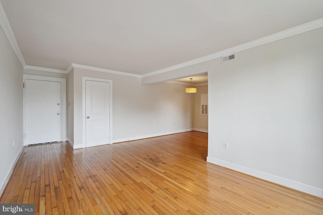 empty room featuring light hardwood / wood-style flooring and ornamental molding