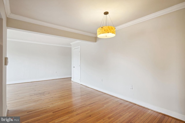 empty room with crown molding and hardwood / wood-style floors