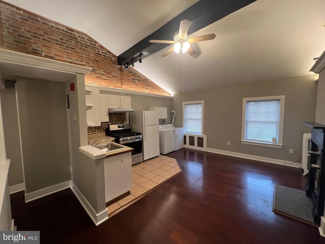 kitchen featuring white cabinets, white fridge, decorative backsplash, lofted ceiling with beams, and stainless steel range with gas stovetop