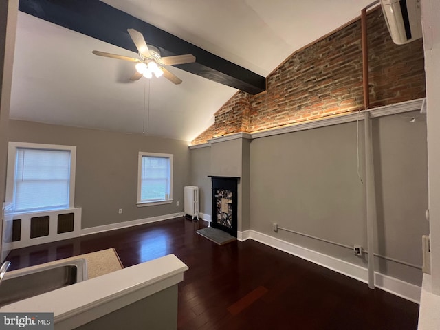 unfurnished living room with ceiling fan, dark hardwood / wood-style floors, lofted ceiling with beams, brick wall, and radiator heating unit