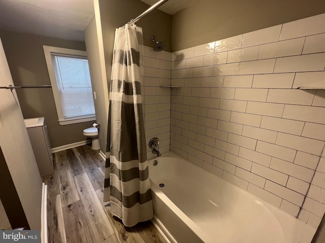 full bathroom featuring toilet, shower / bath combination with curtain, hardwood / wood-style flooring, and vanity