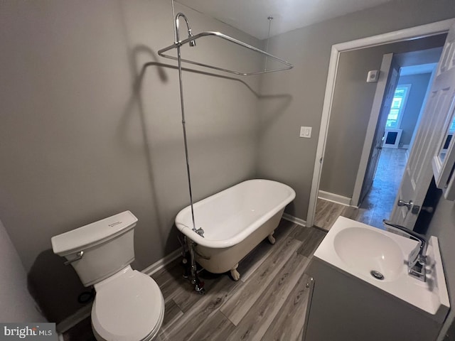 bathroom featuring toilet, sink, a bathing tub, and hardwood / wood-style flooring