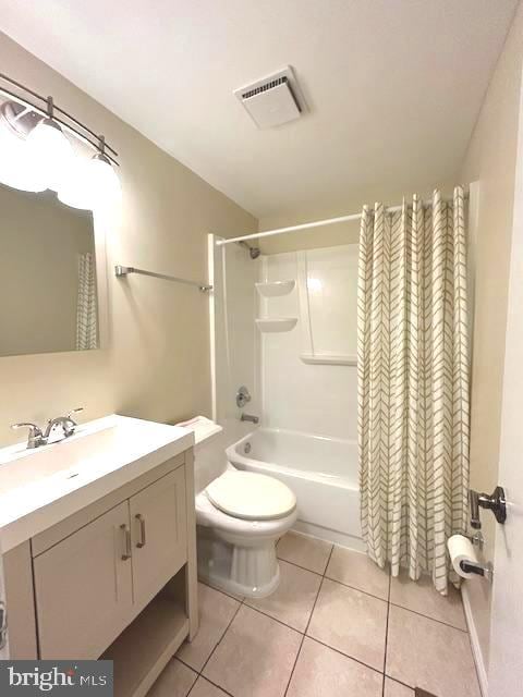 full bathroom featuring shower / tub combo with curtain, vanity, tile patterned floors, and toilet