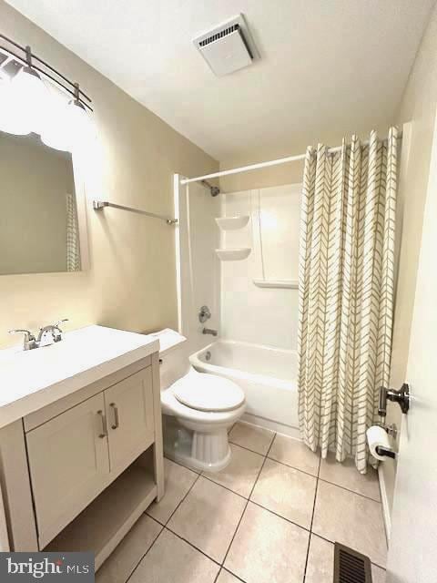 full bathroom featuring toilet, tile patterned floors, shower / bathtub combination with curtain, and vanity