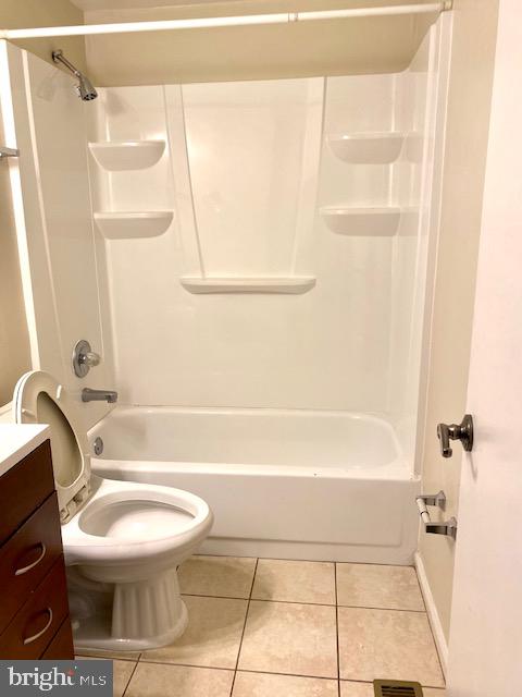 full bathroom featuring washtub / shower combination, vanity, toilet, and tile patterned flooring