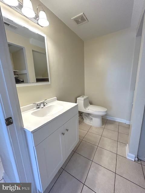 bathroom featuring vanity, tile patterned floors, and toilet