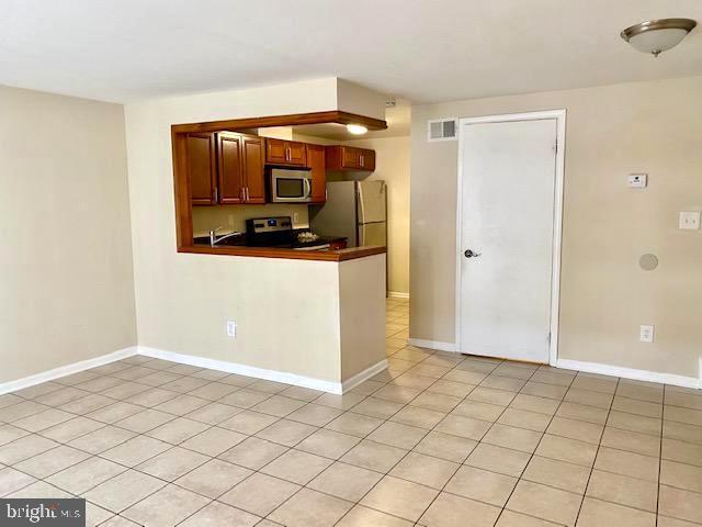 kitchen featuring stainless steel appliances and light tile patterned floors