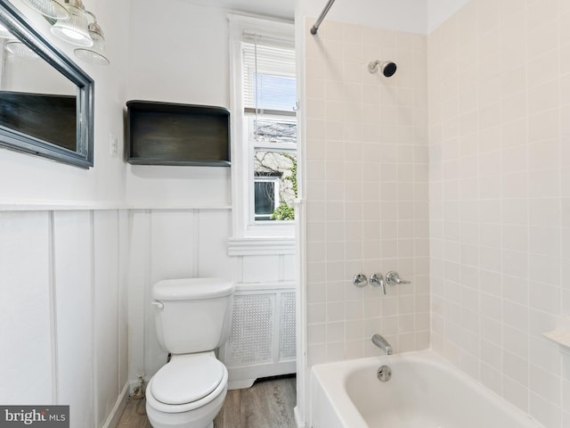 bathroom featuring toilet, tiled shower / bath combo, and wood-type flooring